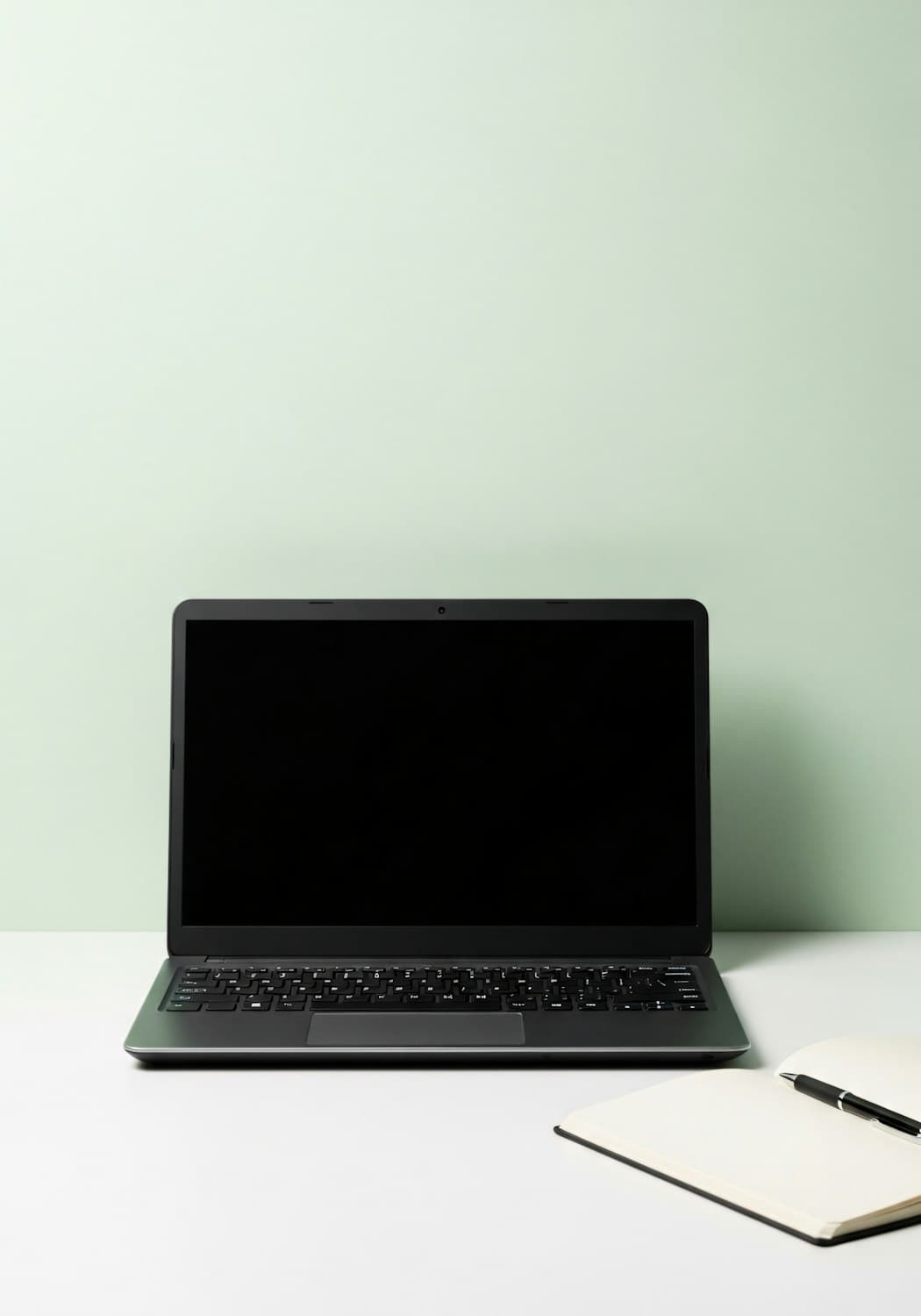A laptop and an open notebook on a clean, bright desk
